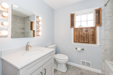 Mid-sized transitional 3/4 gray tile, white tile and porcelain tile porcelain tile and gray floor bathroom photo in DC Metro with shaker cabinets, white cabinets, a two-piece toilet, gray walls, an undermount sink and quartzite countertops