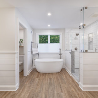 Inspiration för stora lantliga flerfärgat en-suite badrum, med skåp i shakerstil, vita skåp, ett fristående badkar, en hörndusch, en toalettstol med hel cisternkåpa, vit kakel, tunnelbanekakel, grå väggar, klinkergolv i porslin, ett undermonterad handfat, marmorbänkskiva, brunt golv och dusch med gångjärnsdörr