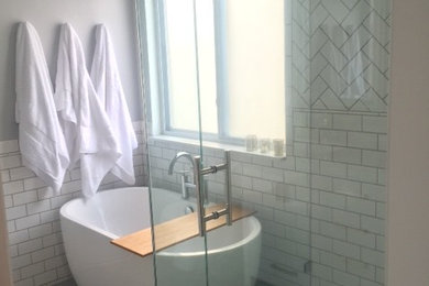 Foto på ett mellanstort vintage vit en-suite badrum, med luckor med profilerade fronter, vita skåp, ett fristående badkar, en hörndusch, vit kakel, tunnelbanekakel, grå väggar, betonggolv, ett undermonterad handfat, bänkskiva i kvarts, grått golv och dusch med gångjärnsdörr