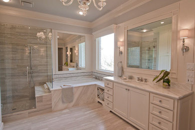 Photo of a large classic ensuite bathroom in Cincinnati with shaker cabinets, a submerged bath, a corner shower, beige tiles, stone tiles and travertine flooring.