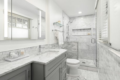На фото: главная ванная комната среднего размера в стиле неоклассика (современная классика) с фасадами с утопленной филенкой, серыми фасадами, душем в нише, раздельным унитазом, серой плиткой, мраморной плиткой, белыми стенами, мраморным полом, врезной раковиной, мраморной столешницей, серым полом, душем с распашными дверями и белой столешницей