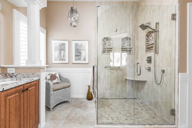 Inspiration for a large transitional master beige tile and porcelain tile porcelain tile and multicolored floor bathroom remodel in Indianapolis with beaded inset cabinets, medium tone wood cabinets, beige walls, an undermount sink, granite countertops and multicolored countertops