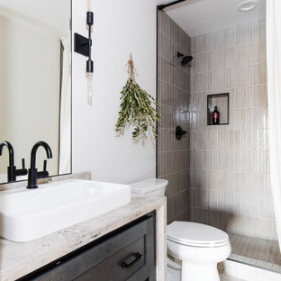 This is an example of a transitional bathroom in Phoenix with shaker cabinets, black cabinets, an alcove shower, gray tile, white walls, a vessel sink, beige floor, a shower curtain, beige benchtops, a single vanity and a built-in vanity.