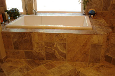 Transitional brown tile and stone tile travertine floor and brown floor drop-in bathtub photo in Other