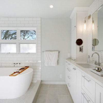 Transitional master white tile gray floor and double-sink bathroom photo in Austin with recessed-panel cabinets, white cabinets, gray walls, an undermount sink, white countertops and a built-in vanity