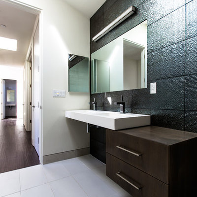 Bathroom - mid-sized modern 3/4 black tile and subway tile ceramic tile and beige floor bathroom idea in San Diego with a vessel sink, flat-panel cabinets, dark wood cabinets, gray walls, solid surface countertops and white countertops