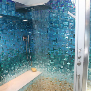 Foto di una grande stanza da bagno padronale tropicale con ante lisce, ante nere, vasca da incasso, doccia aperta, WC monopezzo, piastrelle blu, piastrelle di vetro, pareti blu, pavimento con piastrelle in ceramica, lavabo a colonna, top in superficie solida, pavimento beige e doccia aperta