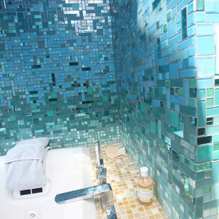 Foto di una grande stanza da bagno padronale tropicale con ante lisce, ante nere, vasca da incasso, doccia aperta, WC monopezzo, piastrelle blu, piastrelle di vetro, pareti blu, pavimento con piastrelle in ceramica, lavabo a colonna, top in superficie solida, pavimento beige e doccia aperta