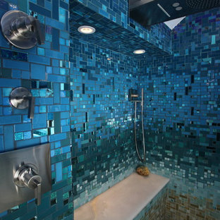 Ispirazione per una grande stanza da bagno padronale tropicale con ante lisce, ante nere, vasca da incasso, doccia aperta, WC monopezzo, piastrelle blu, piastrelle di vetro, pareti blu, pavimento con piastrelle in ceramica, lavabo a colonna, top in superficie solida, pavimento beige e doccia aperta