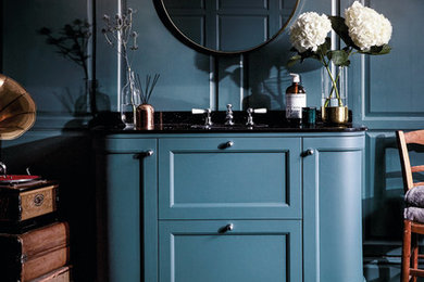 Diseño de cuarto de baño clásico renovado de tamaño medio con armarios estilo shaker, puertas de armario azules, paredes azules, suelo de madera oscura, lavabo encastrado, encimera de mármol y suelo marrón