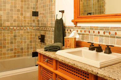 Elegant multicolored tile and stone tile limestone floor bathroom photo in Philadelphia with a drop-in sink, medium tone wood cabinets, granite countertops, white walls and flat-panel cabinets