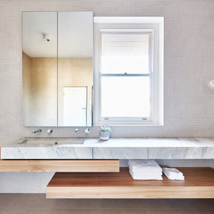 Design ideas for a mid-sized contemporary kids bathroom in Melbourne with flat-panel cabinets, light wood cabinets, white tile, beige walls, porcelain floors, an undermount sink, marble benchtops, beige floor, mosaic tile and white benchtops.