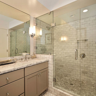 Example of a large trendy master gray tile and mosaic tile pebble tile floor alcove shower design in San Francisco with recessed-panel cabinets, beige cabinets, marble countertops and beige walls