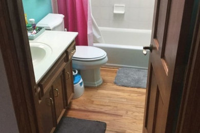 Imagen de cuarto de baño tradicional de tamaño medio con bañera empotrada, combinación de ducha y bañera, paredes azules, suelo laminado, aseo y ducha, suelo gris y ducha con cortina