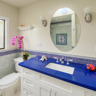 Esempio di una stanza da bagno con doccia mediterranea di medie dimensioni con lavabo sottopiano, ante in stile shaker, ante bianche, doccia aperta, piastrelle blu, piastrelle rosse, piastrelle bianche, piastrelle in ceramica, pareti bianche, top in quarzo composito, porta doccia a battente, pavimento con piastrelle in ceramica, pavimento multicolore, vasca ad alcova, WC a due pezzi e top blu