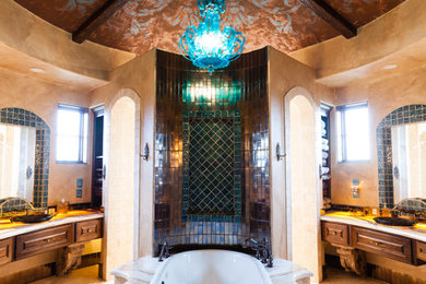 オースティンにある高級な中くらいな地中海スタイルのおしゃれなマスターバスルーム (ドロップイン型浴槽、茶色いタイル、緑のタイル、マルチカラーのタイル、メタルタイル、ベージュの壁) の写真