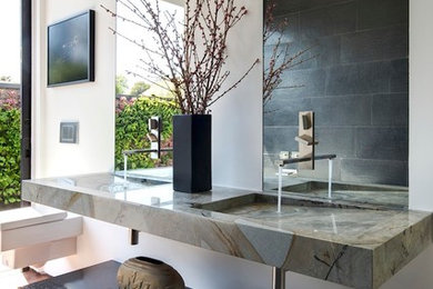 Modelo de cuarto de baño contemporáneo con lavabo integrado, sanitario de pared y baldosas y/o azulejos negros