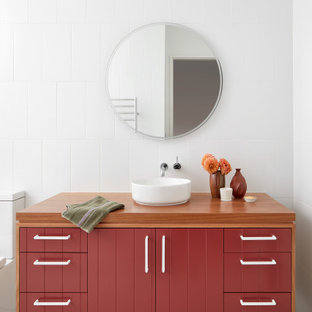 Large contemporary master bathroom in Melbourne with red cabinets, a two-piece toilet, white tile, white walls, terrazzo floors, wood benchtops, brown benchtops, a single vanity, a freestanding vanity, flat-panel cabinets, a vessel sink, grey floor and vaulted.