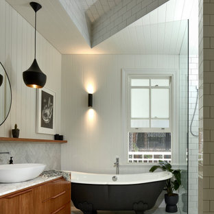 Contemporary bathroom in Brisbane with flat-panel cabinets, medium wood cabinets, a claw-foot tub, an alcove shower, white tile, subway tile, white walls, a vessel sink, white floor, an open shower, white benchtops, a single vanity, a freestanding vanity, recessed and planked wall panelling.