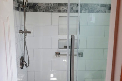 他の地域にある中くらいなトランジショナルスタイルのおしゃれなマスターバスルーム (アルコーブ型シャワー、分離型トイレ、白いタイル、磁器タイル、引戸のシャワー、洗面台1つ) の写真