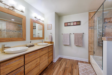 Mid-sized trendy master brown tile ceramic tile bathroom photo in Cincinnati with a vessel sink, flat-panel cabinets, brown cabinets and granite countertops