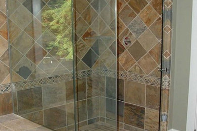 Mid-sized tuscan brown tile and stone tile slate floor bathroom photo in New York with gray walls