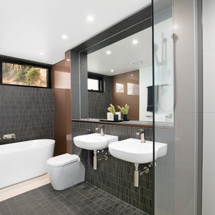 Design ideas for a contemporary master bathroom in Sydney with a one-piece toilet, gray tile, brown walls, a freestanding tub, an open shower, matchstick tile, a wall-mount sink, multi-coloured floor, an open shower, wood benchtops and brown benchtops.