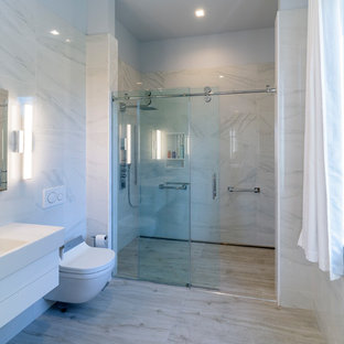 Esempio di una piccola stanza da bagno con doccia moderna con ante lisce, ante bianche, doccia a filo pavimento, bidè, pistrelle in bianco e nero, piastrelle multicolore, piastrelle a listelli, pareti multicolore, pavimento in gres porcellanato, lavabo integrato, top in superficie solida, pavimento grigio, porta doccia scorrevole e top bianco