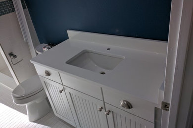 Ejemplo de cuarto de baño contemporáneo de tamaño medio con armarios tipo mueble, puertas de armario blancas, aseo y ducha y encimera de acrílico