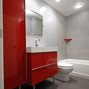 Mittelgroßes Modernes Kinderbad mit flächenbündigen Schrankfronten, roten Schränken, Badewanne in Nische, Duschbadewanne, Wandtoilette mit Spülkasten, grauen Fliesen, Porzellanfliesen, blauer Wandfarbe, Porzellan-Bodenfliesen, integriertem Waschbecken und Mineralwerkstoff-Waschtisch in New York