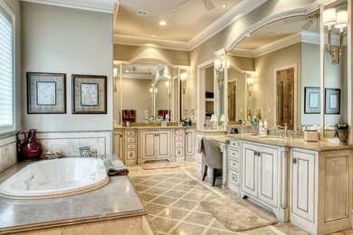 Design ideas for a medium sized traditional ensuite bathroom in Cincinnati with raised-panel cabinets, beige cabinets, an alcove bath, limestone tiles, limestone flooring, a submerged sink, limestone worktops and beige floors.