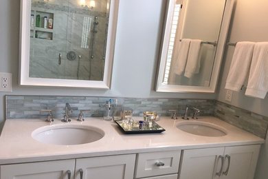 Walk-in shower - mid-sized transitional master porcelain tile, gray tile and white tile marble floor walk-in shower idea in Nashville with shaker cabinets, white cabinets, quartz countertops, a two-piece toilet, gray walls and an undermount sink