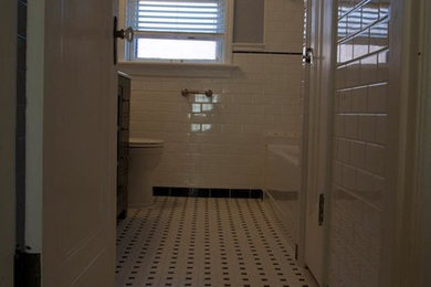 Example of a mid-sized arts and crafts master white tile and subway tile ceramic tile bathroom design in St Louis with an integrated sink, glass-front cabinets, dark wood cabinets, solid surface countertops, a one-piece toilet and gray walls