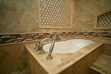 Large transitional master beige tile and travertine tile mosaic tile floor and beige floor bathroom photo in Austin with raised-panel cabinets, white cabinets, an undermount tub, a two-piece toilet, beige walls, an undermount sink and quartzite countertops