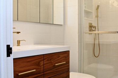 Small elegant master white tile and porcelain tile porcelain tile and blue floor alcove shower photo in New York with furniture-like cabinets, medium tone wood cabinets, a one-piece toilet, white walls, a wall-mount sink, limestone countertops and a hinged shower door
