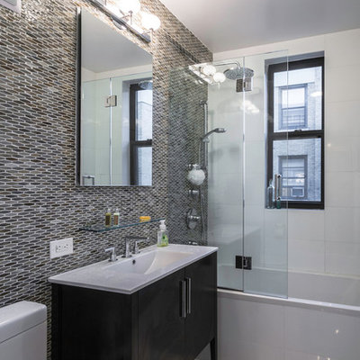 Inspiration for a mid-sized contemporary 3/4 gray tile and mosaic tile porcelain tile bathroom remodel in New York with black cabinets, a two-piece toilet, gray walls, an integrated sink and flat-panel cabinets