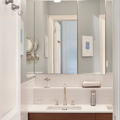 Inspiration for a mid-sized transitional master white tile and stone tile mosaic tile floor and gray floor alcove shower remodel in New York with flat-panel cabinets, medium tone wood cabinets, a wall-mount toilet, white walls, an undermount sink, glass countertops and a hinged shower door