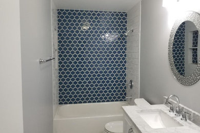 Réalisation d'une salle de bain principale design de taille moyenne avec WC à poser, des carreaux de porcelaine, un mur gris, un sol en marbre, un lavabo encastré, un sol multicolore et un plan de toilette blanc.