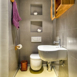 Design ideas for a contemporary bathroom with a wall-mount sink, a wall-mount toilet and yellow floor.