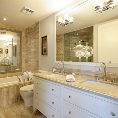 Inspiration for a mid-sized transitional master brown tile and limestone tile alcove bathtub remodel in Toronto with white cabinets, white walls, an undermount sink and beaded inset cabinets