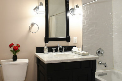 Inspiration for a mid-sized timeless 3/4 white tile and porcelain tile mosaic tile floor and white floor drop-in bathtub remodel in DC Metro with furniture-like cabinets, black cabinets, a two-piece toilet, beige walls, an undermount sink, quartz countertops and white countertops