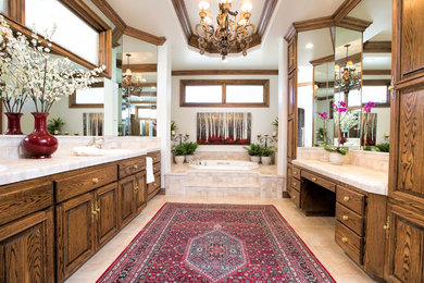 サンタバーバラにあるトラディショナルスタイルのおしゃれなマスターバスルーム (オーバーカウンターシンク、レイズドパネル扉のキャビネット、濃色木目調キャビネット、ドロップイン型浴槽) の写真