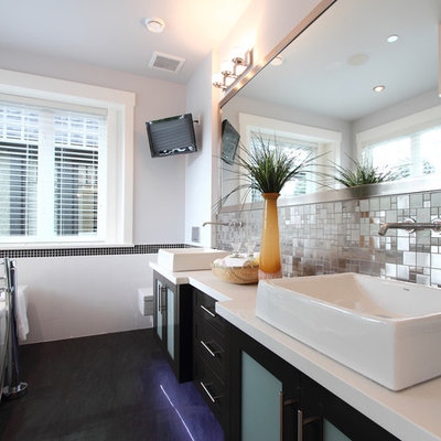 Freestanding bathtub - contemporary black floor freestanding bathtub idea in Vancouver with a vessel sink