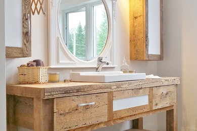 Design ideas for a coastal bathroom in Montreal with a built-in sink, medium wood cabinets, white walls and flat-panel cabinets.