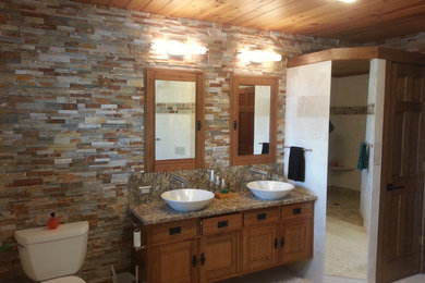Idée de décoration pour une grande salle de bain principale minimaliste en bois brun avec un placard à porte shaker, une douche ouverte, WC séparés, un mur multicolore, un sol en carrelage de céramique, une vasque et un plan de toilette en granite.