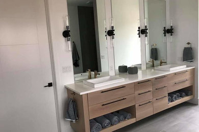 Ejemplo de cuarto de baño contemporáneo con armarios con paneles lisos, puertas de armario de madera clara, encimera de cuarcita y encimeras blancas