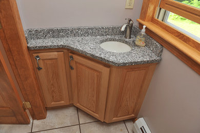 Example of a large bathroom design in Portland Maine with a drop-in sink, recessed-panel cabinets and medium tone wood cabinets
