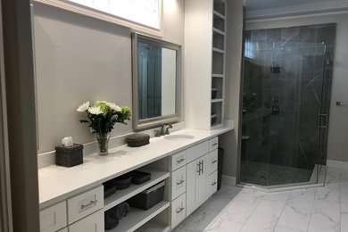 Example of a huge transitional master gray tile and porcelain tile porcelain tile and white floor bathroom design in Jacksonville with shaker cabinets, white cabinets, a two-piece toilet, gray walls, an undermount sink, quartz countertops, a hinged shower door and white countertops