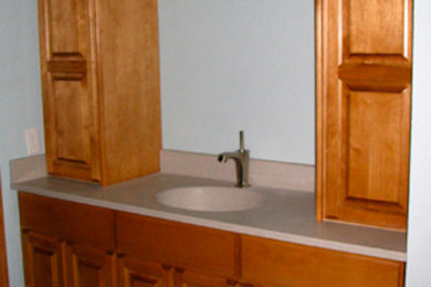 Bathroom - mid-sized master ceramic tile bathroom idea in Milwaukee with a drop-in sink, raised-panel cabinets, medium tone wood cabinets, granite countertops and white walls