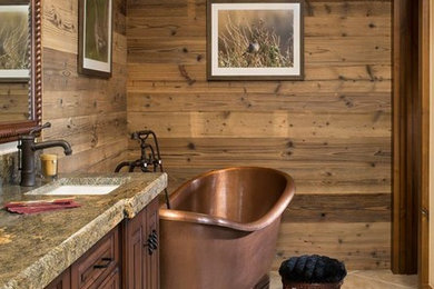 This is an example of a medium sized rustic bathroom in Wichita with raised-panel cabinets, dark wood cabinets, a freestanding bath, brown walls, ceramic flooring, a submerged sink and granite worktops.